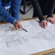 Homme noir d'âge moyen et jeune femme adulte discutant d'un plan architectural