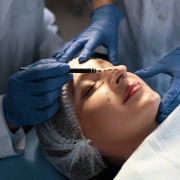 Médecin et infirmière préparant une patiente à une chirurgie esthétique en clinique