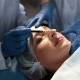 Médecin et infirmière préparant une patiente à une chirurgie esthétique en clinique