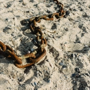 Concept d'abandon, vieilles chaînes rouillées et cassées jetées dans le sable d'une plage