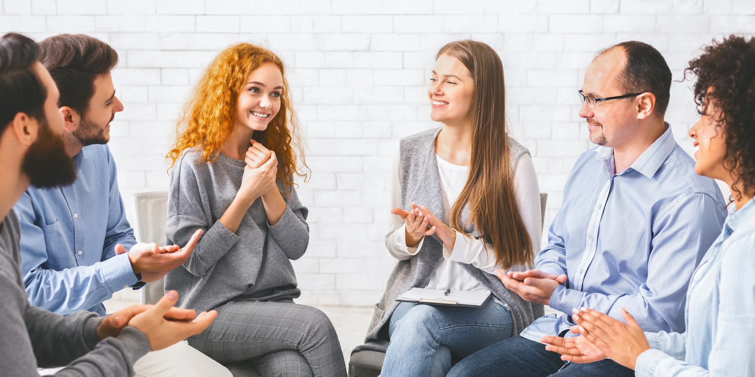 Les gens applaudissent à une jeune femme lors d'une séance de thérapie en réadaptation Les gens applaudissent à une jeune femme lors d'une séance de thérapie en réadaptation