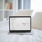 Ordinateur portable placé sur le lit avec un site Web de cosmétiques à l'écran