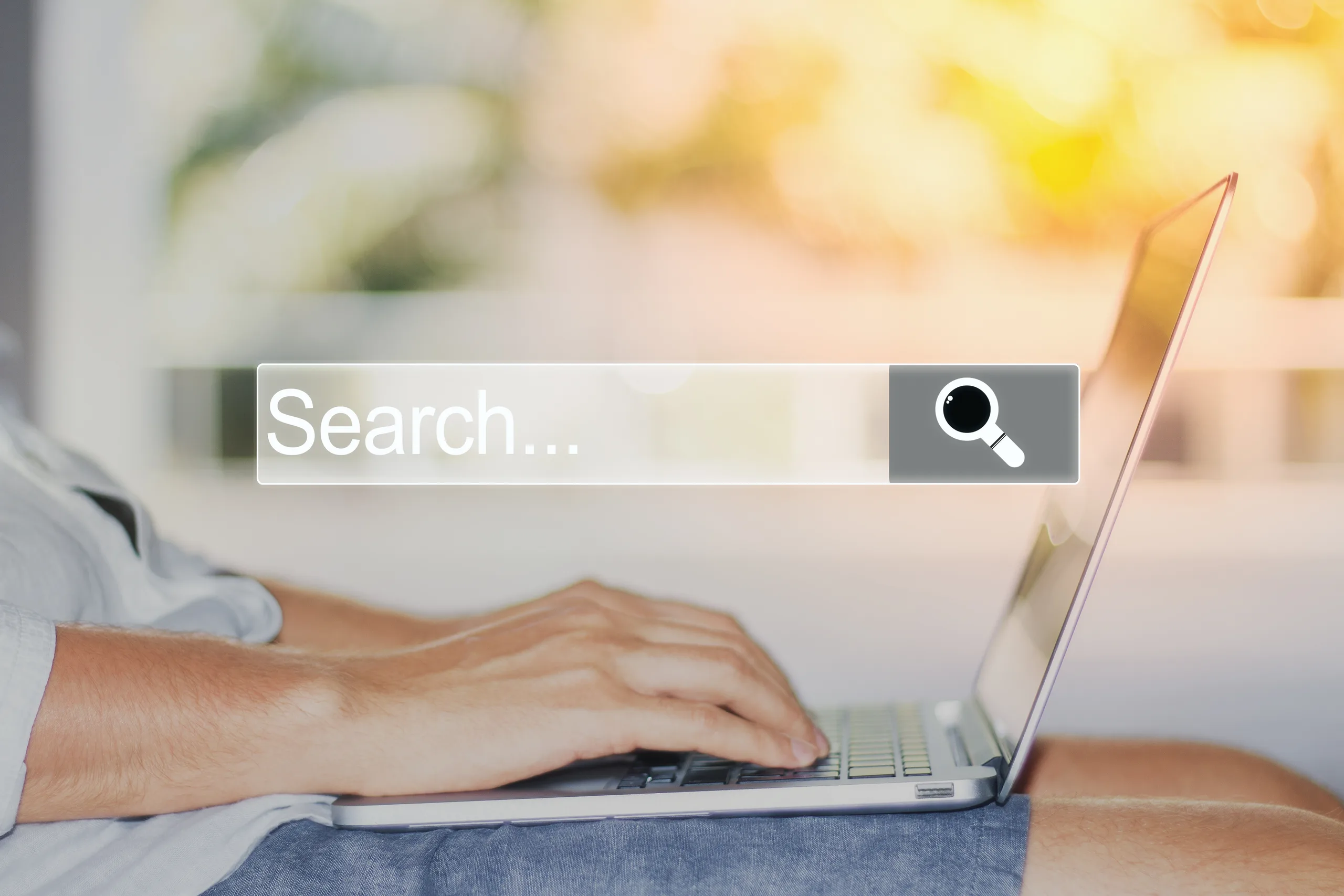 Personne effectuant une recherche en ligne sur un ordinateur portable Personne effectuant une recherche en ligne sur un ordinateur portable, barre de recherche avec loupe